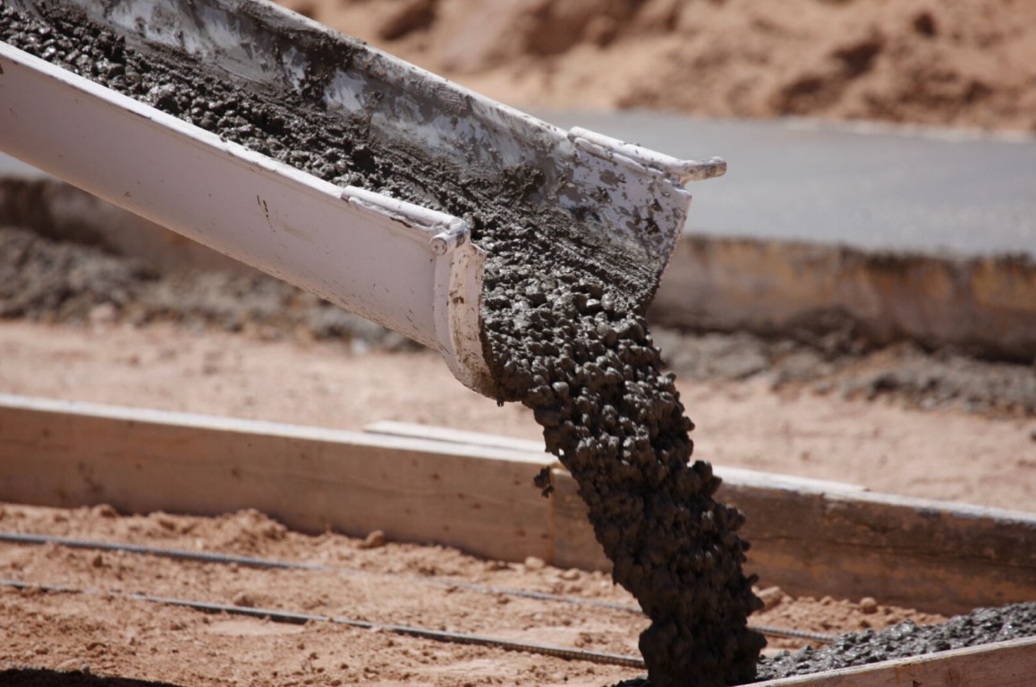 Concrete being poured from a chute into wooden forms over rebar for a foundation in Sioux Falls
